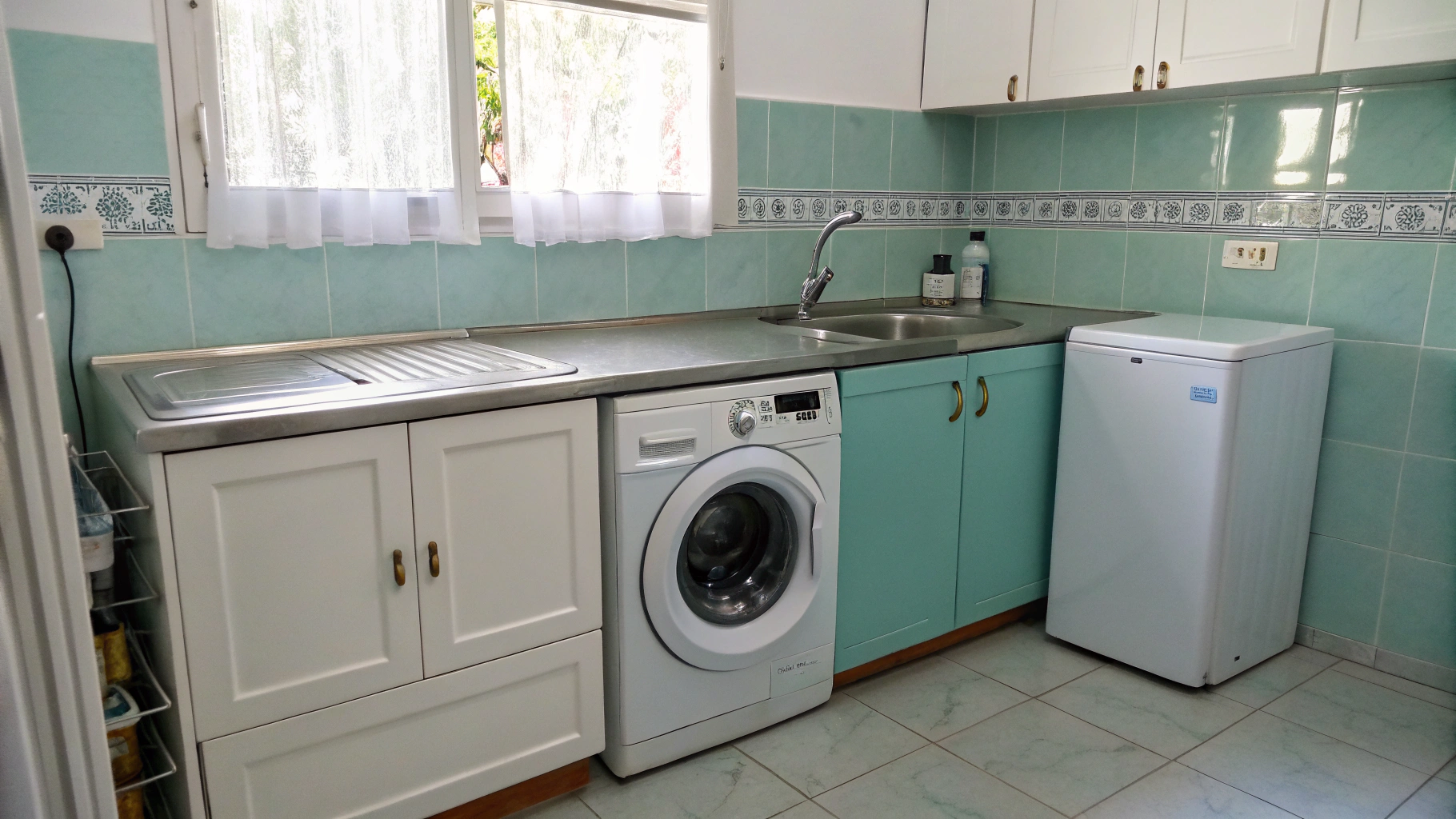 Modern front-load washing machine and laundry dryer side by side in a residential laundry room